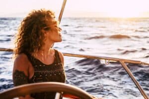 femme heureuse et épanouie sur un bateau